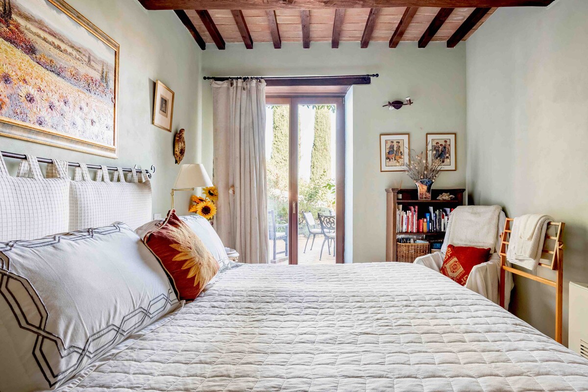 Bedroom with wooden beams opening onto the terrace